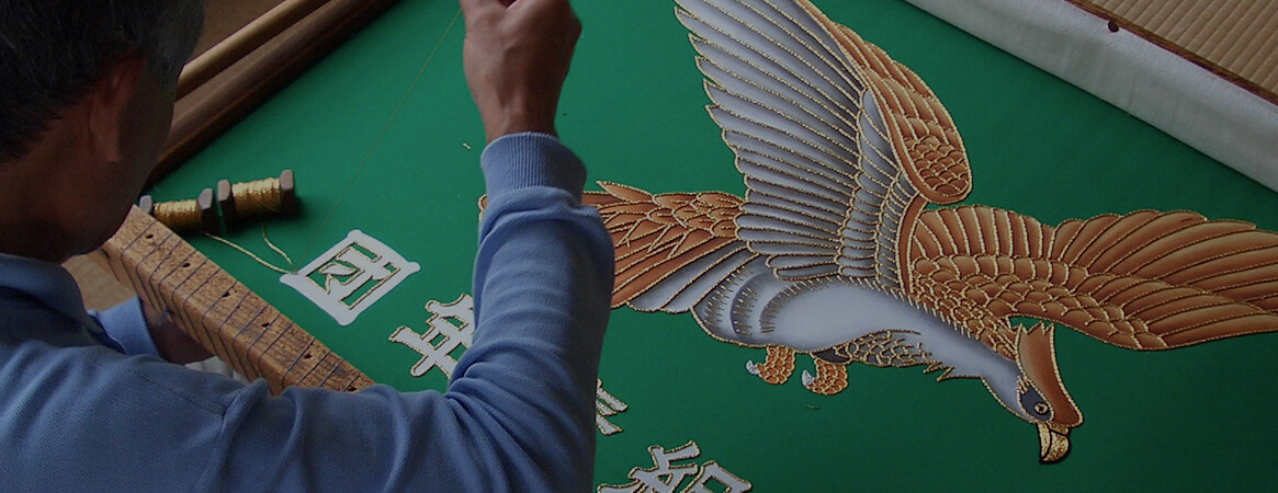 an artisan embroidering a flag